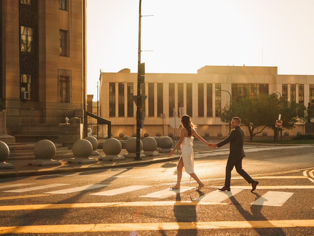 Couple laughing together during golden hour couples session at Buffalo city hall with warm lighting