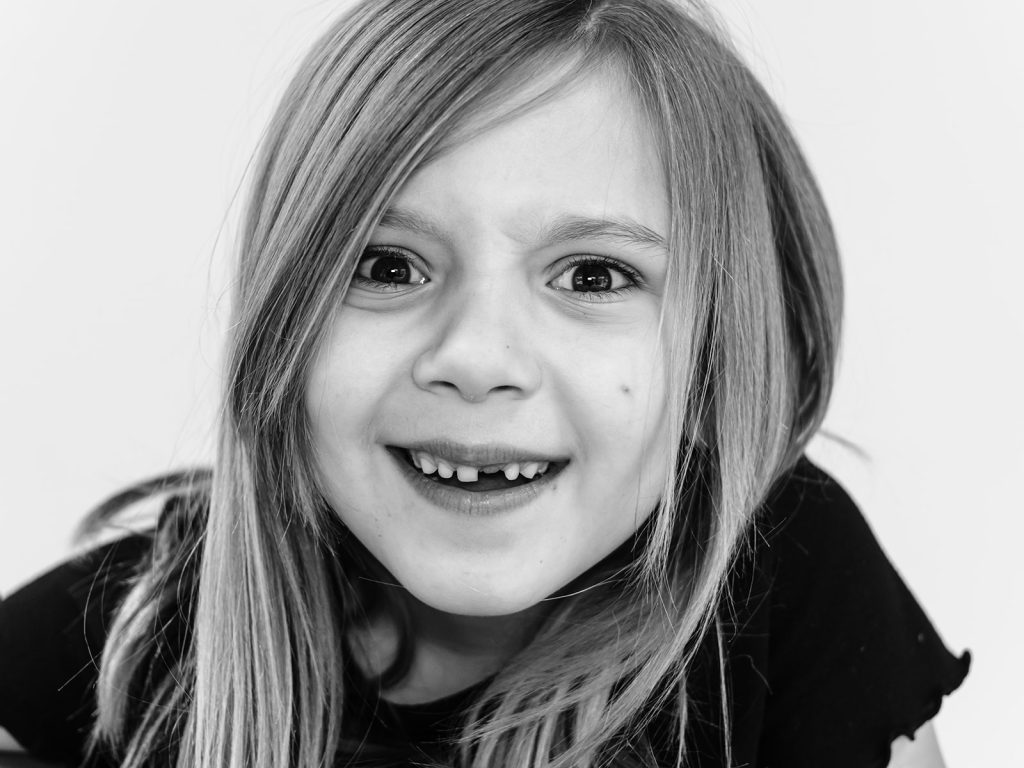 Buffalo personality portrait of smiling child with gap-toothed grin captured in beautiful black and white