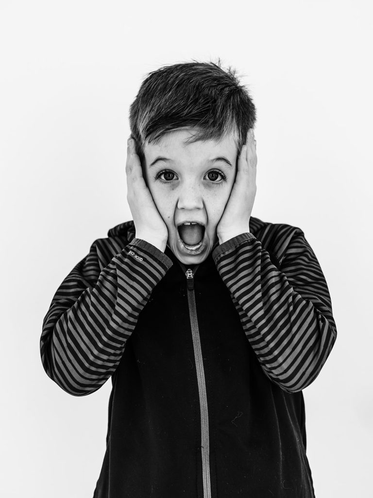 Boy showing genuine personality in black and white portrait by Buffalo photographer